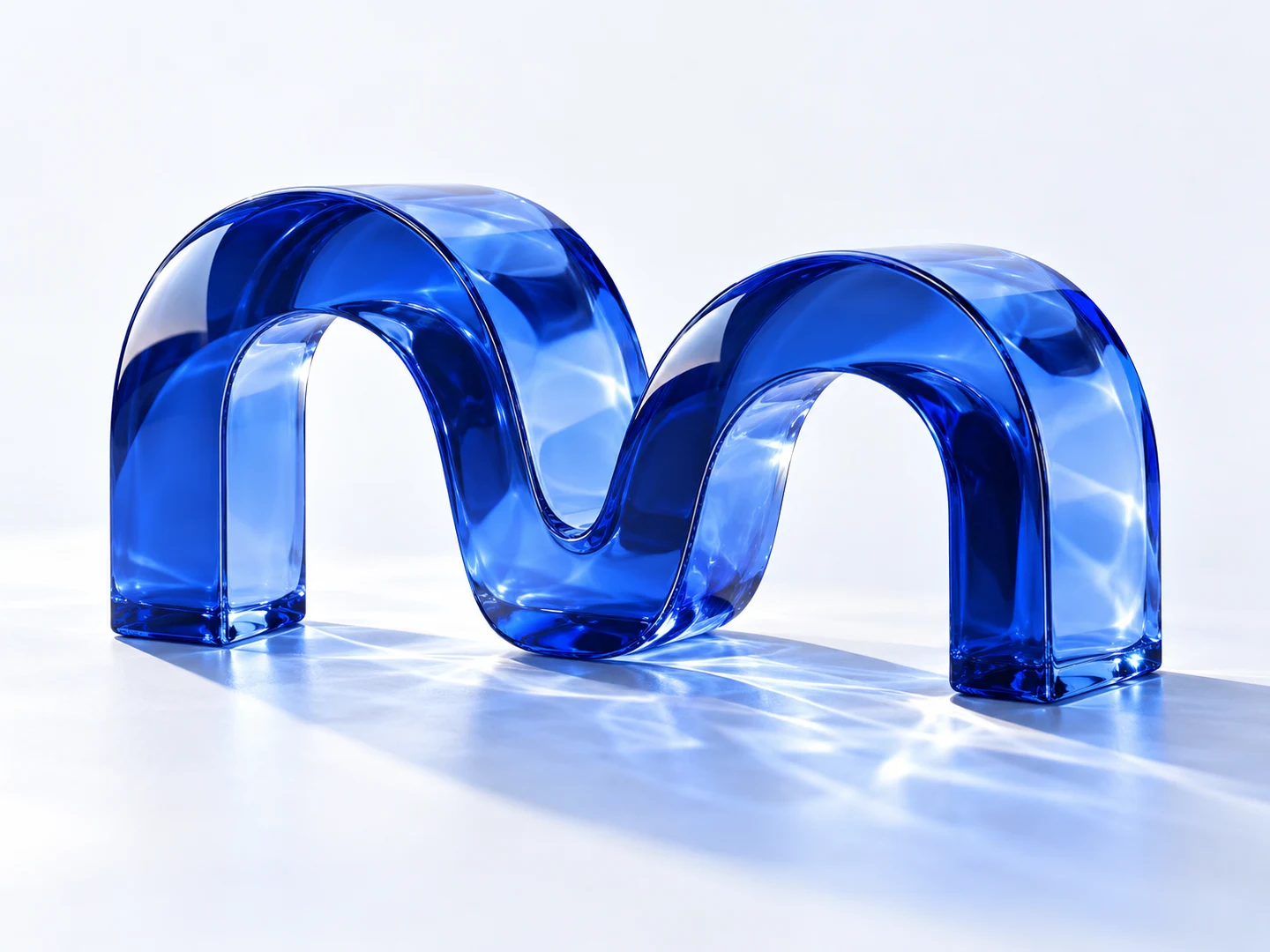 A flowing double-arch sculpture in cobalt blue glass, the Mekora studio mark.